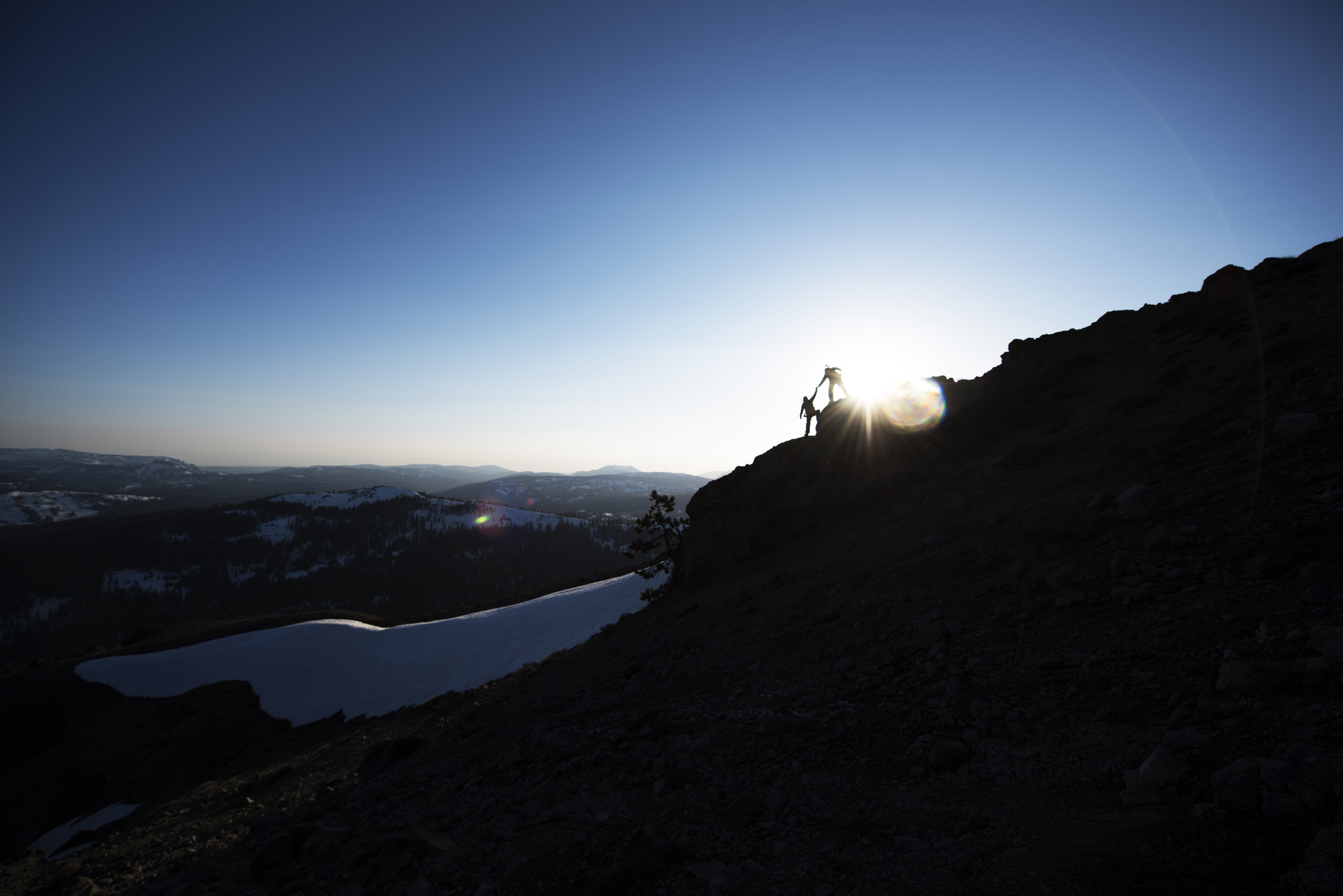 互いに助け合いながら山を登る人たち
